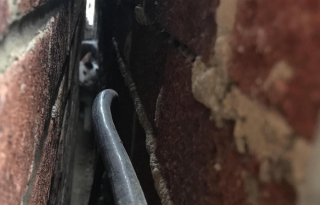 Illustration de l'article : Un chat tombe du toit et se retrouve coincé dans un espace de 8 centimètres entre 2 maisons